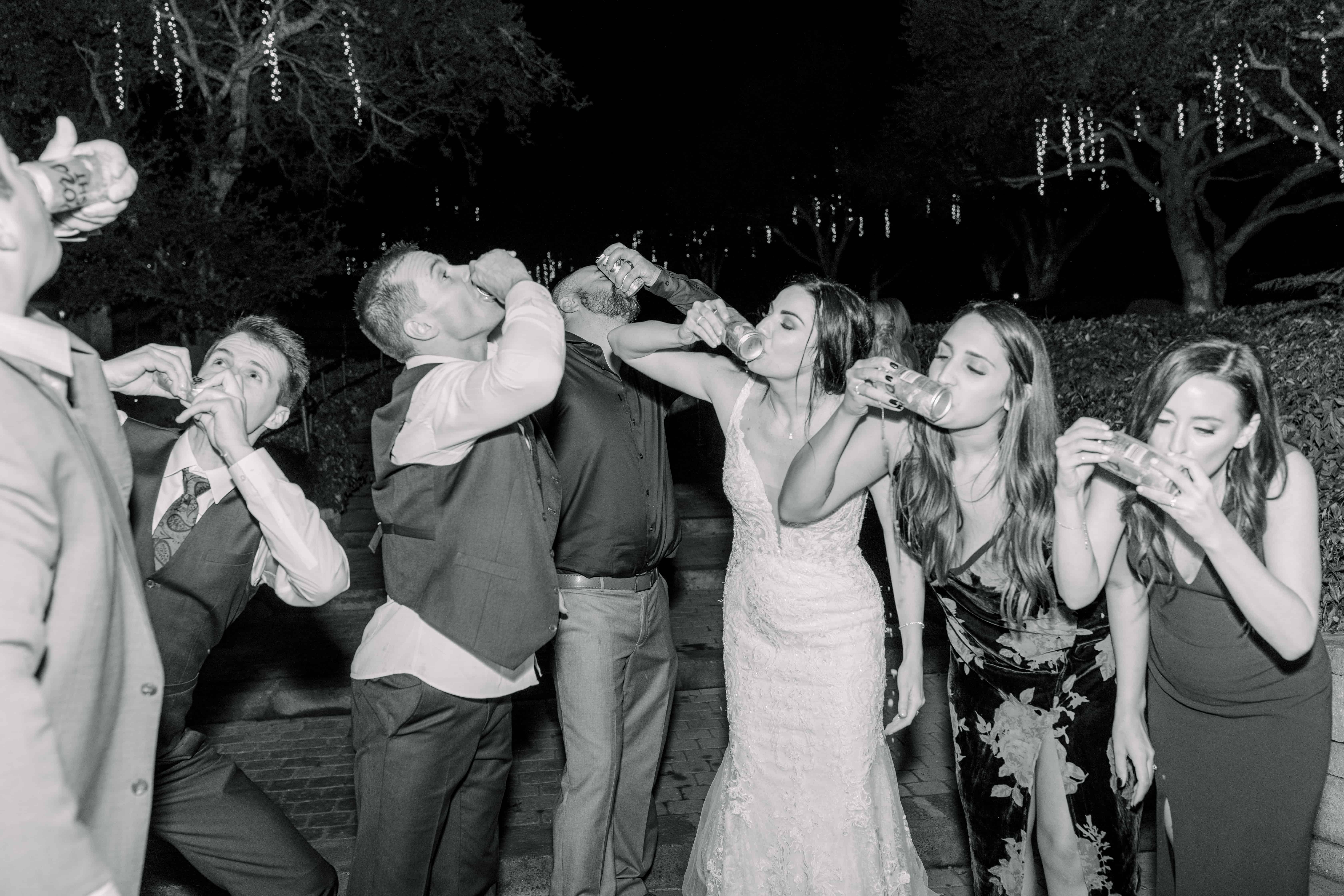 A group of eight people dancing and posing playfully at a nighttime celebration.